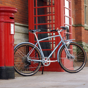 a blue Prospero equipped bicycle next to a red postbox