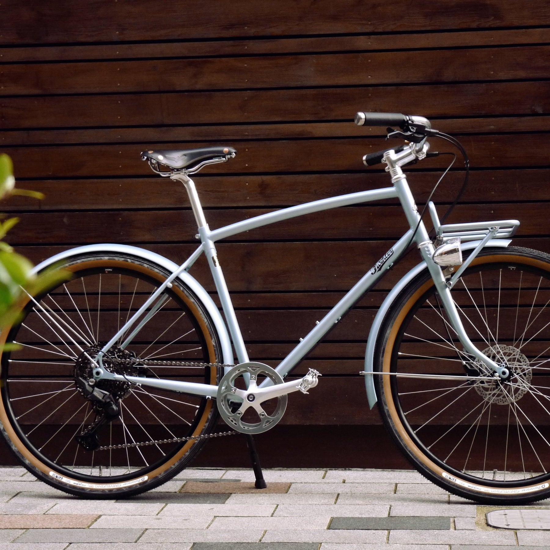 A blue Prospero Equipped bicycle against a wooden wall